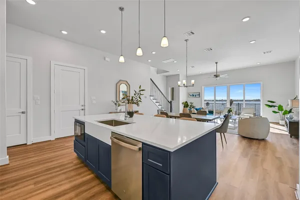 a large kitchen with stainless steel appliances a large center island attached withe living room