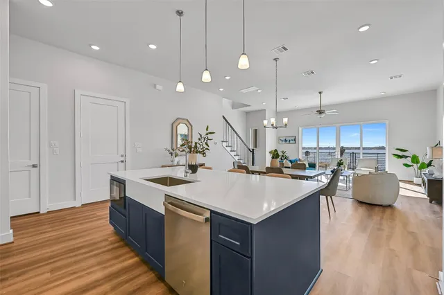 a large kitchen with stainless steel appliances a large center island attached withe living room