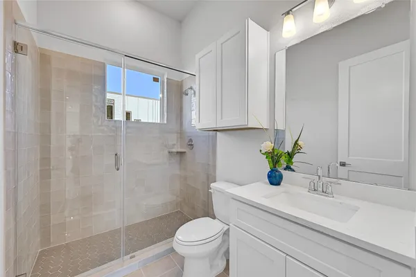 a bathroom with a sink a toilet and shower
