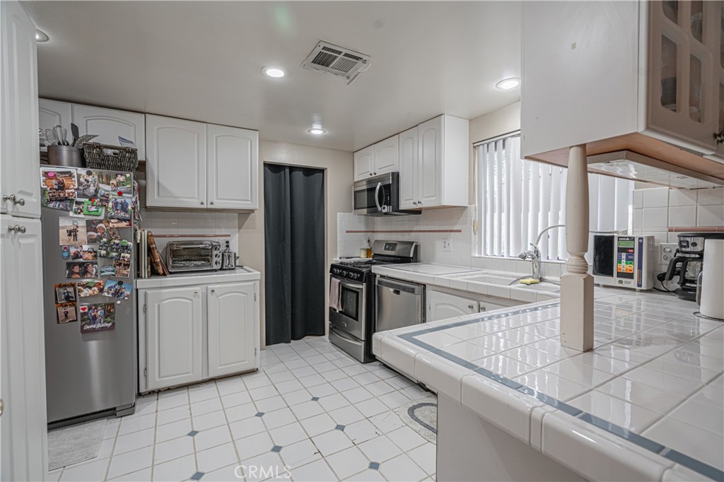 20950 Claire Road Perris, CA 92570 - Photo 43 of 74 a kitchen with granite countertop a stove a sink and a refrigerator