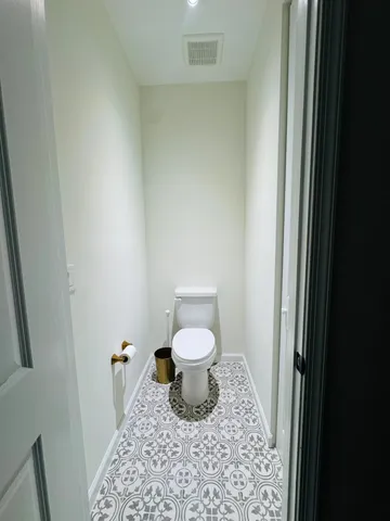 a bathroom with a granite countertop toilet and a sink