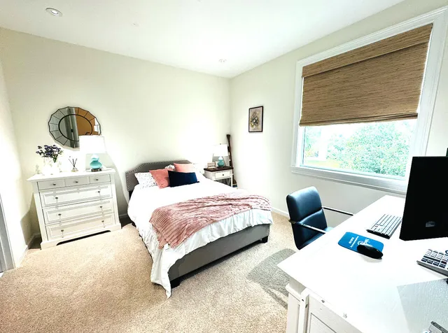 a bedroom with two beds and large window