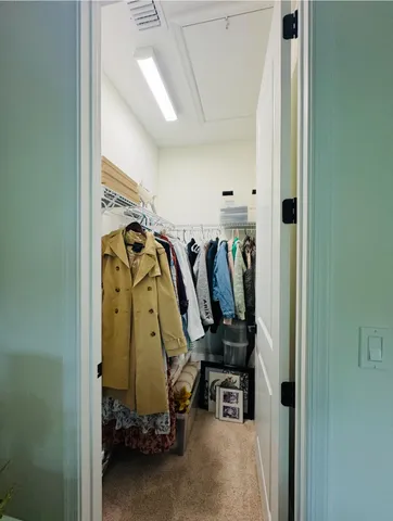 a view of walk in closet with clothes and shoes