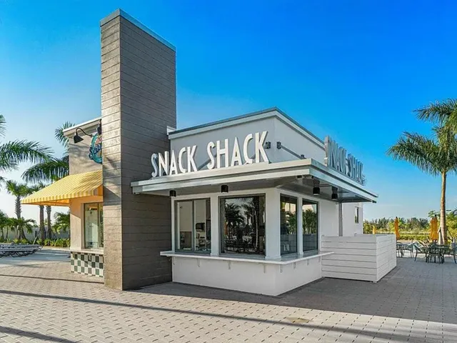 a view of a white house with a large window and potted plants