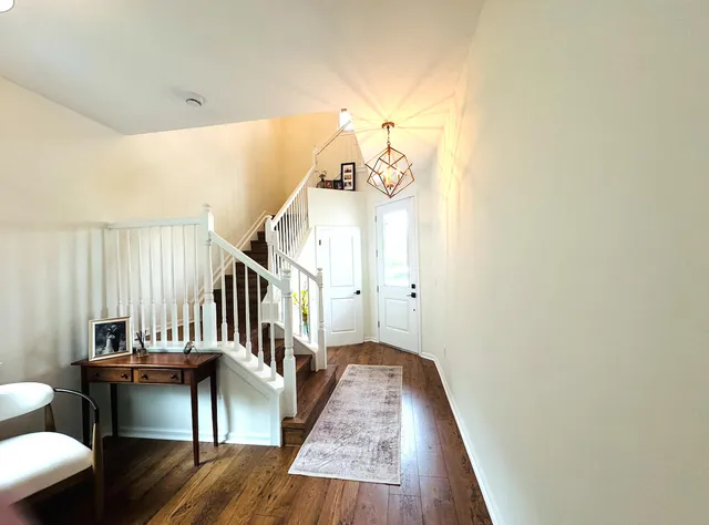 a view of entryway and hall with wooden floor