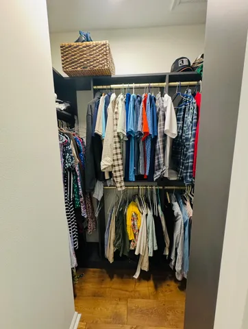 a view of walk in closet with clothes