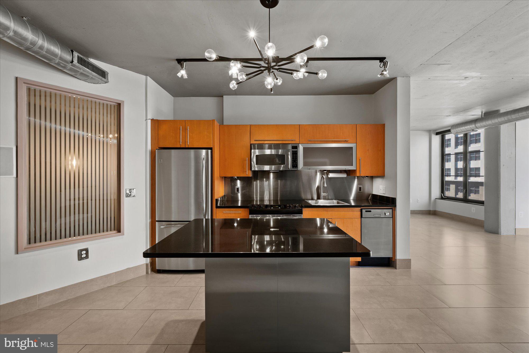 1133 14th Street Northwest, Unit 404 Washington, DC 20005 - Photo 6 of 15 a kitchen with stainless steel appliances granite countertop a sink and a refrigerator