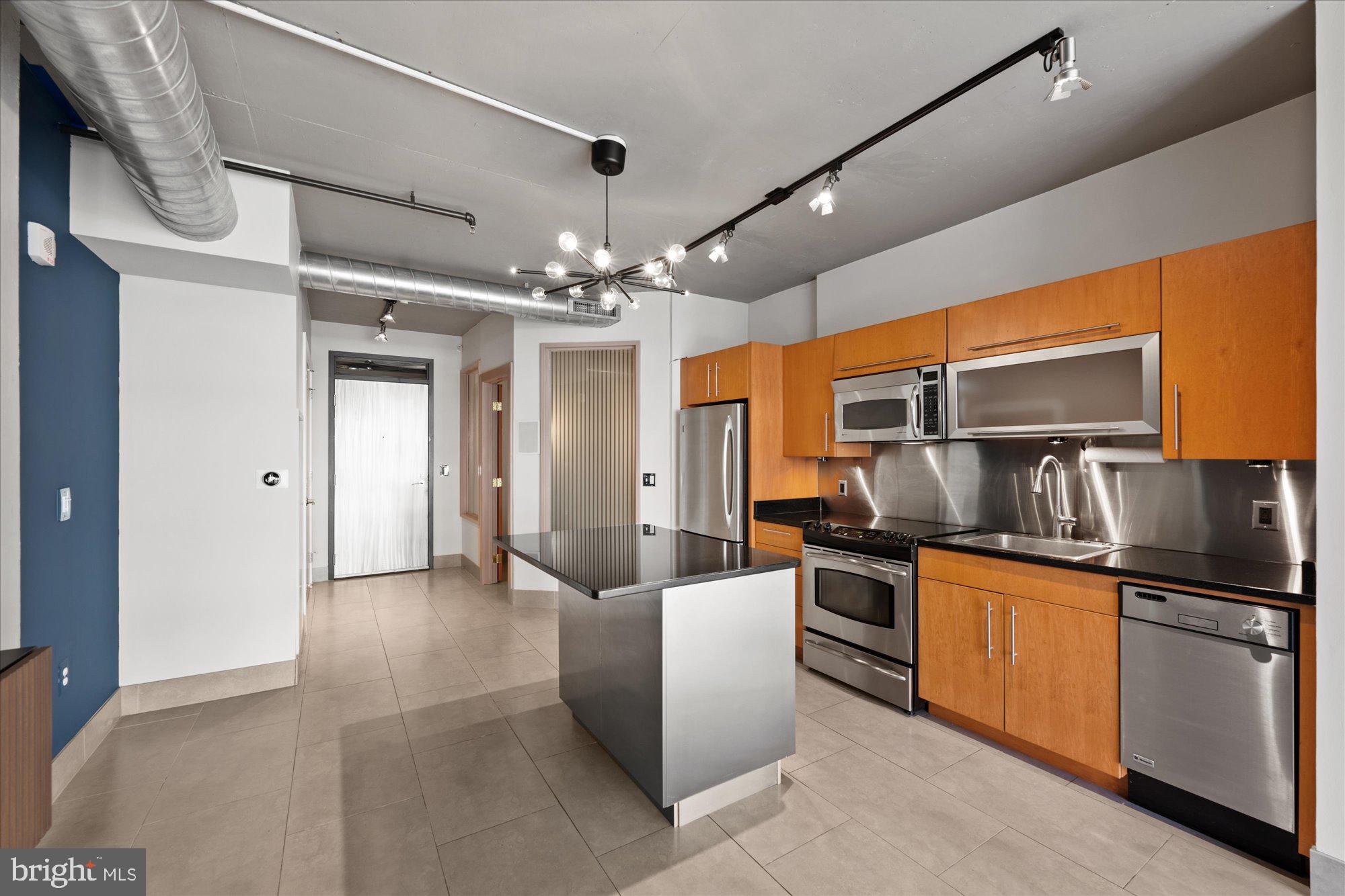 1133 14th Street Northwest, Unit 404 Washington, DC 20005 - Photo 7 of 15 a kitchen with stainless steel appliances granite countertop a sink and refrigerator