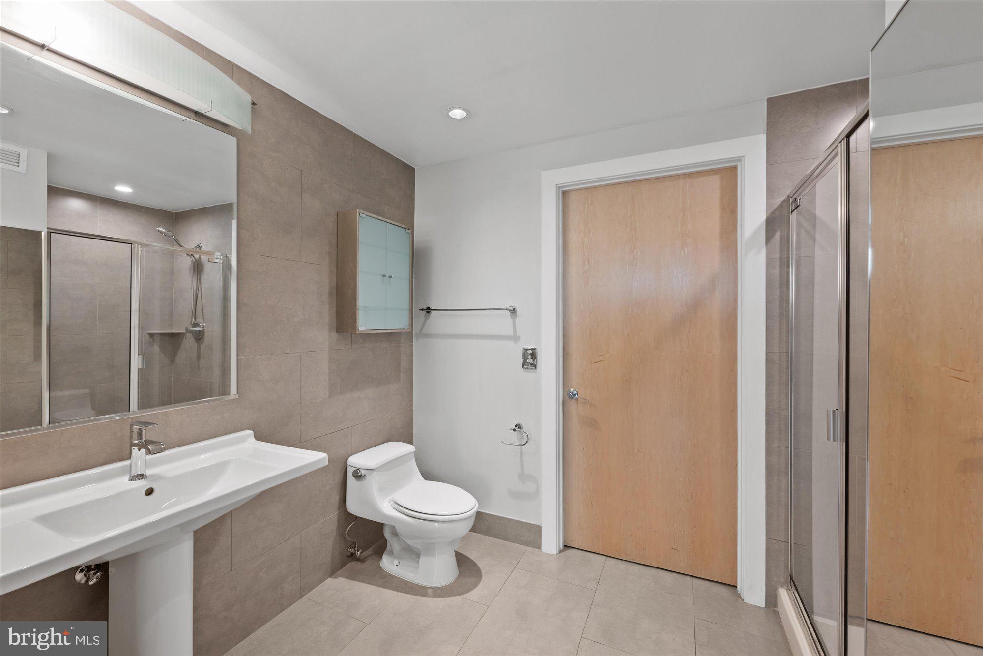 1133 14th Street Northwest, Unit 404 Washington, DC 20005 - Photo 10 of 15 a bathroom with a toilet sink and shower