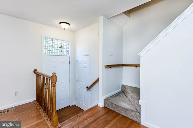 an entryway with wooden floor and cabinet