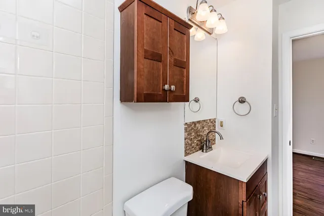 a bathroom with a toilet a sink and mirror
