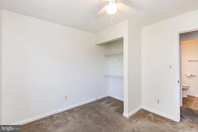 an empty room with a chandelier fan