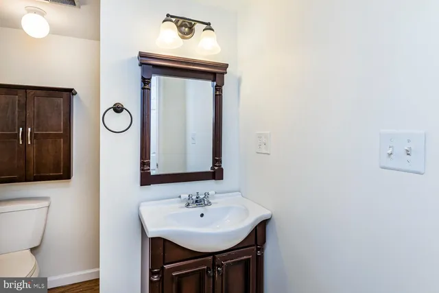 a bathroom with a toilet sink and mirror