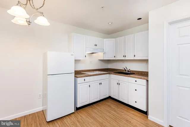 a kitchen with granite countertop white cabinets and white appliances