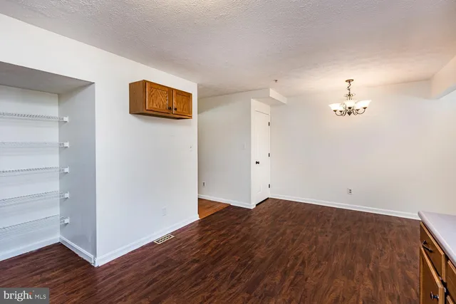 a view of a room with wooden floor and a ceiling fan