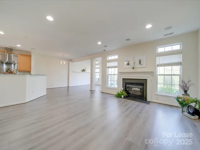 a view of empty room with wooden floor and fireplace