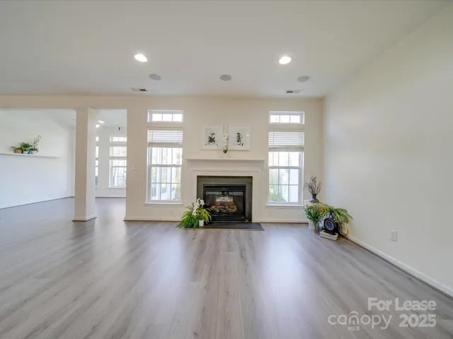 a view of an empty room with window and fire place