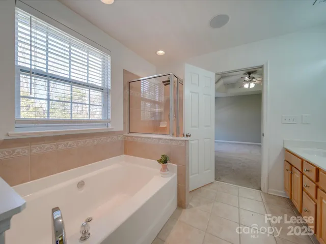 a spacious bathroom with a tub shower and sink