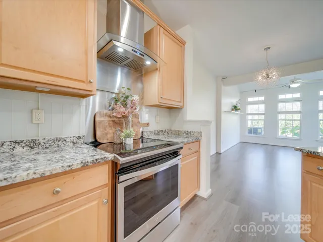 a kitchen with stainless steel appliances granite countertop a stove a sink and a refrigerator
