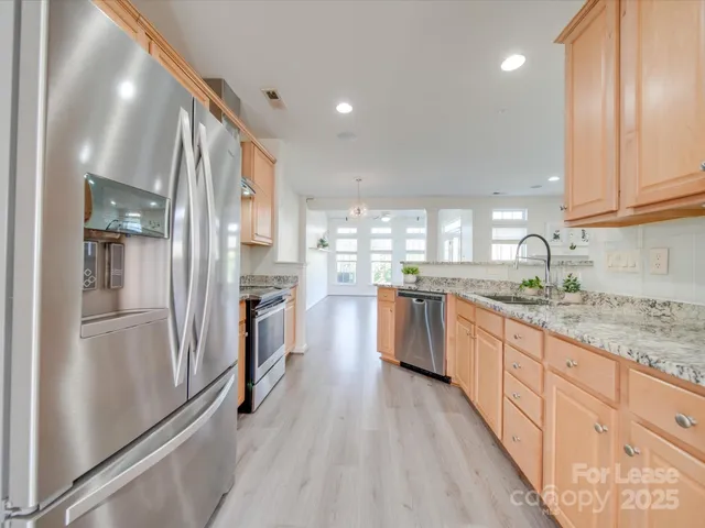 a large kitchen with stainless steel appliances sink a microwave and cabinets