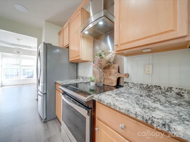 a kitchen with stainless steel appliances granite countertop a sink and a refrigerator