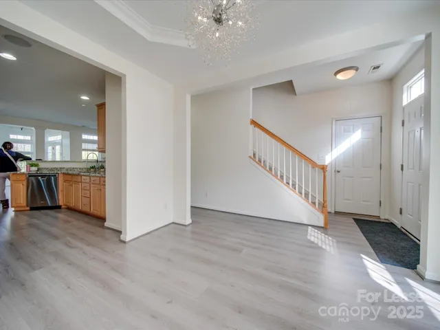 a view of a hallway with wooden floor and a kitchen