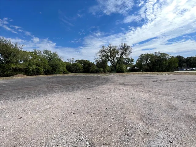 a view of a field with trees in the background