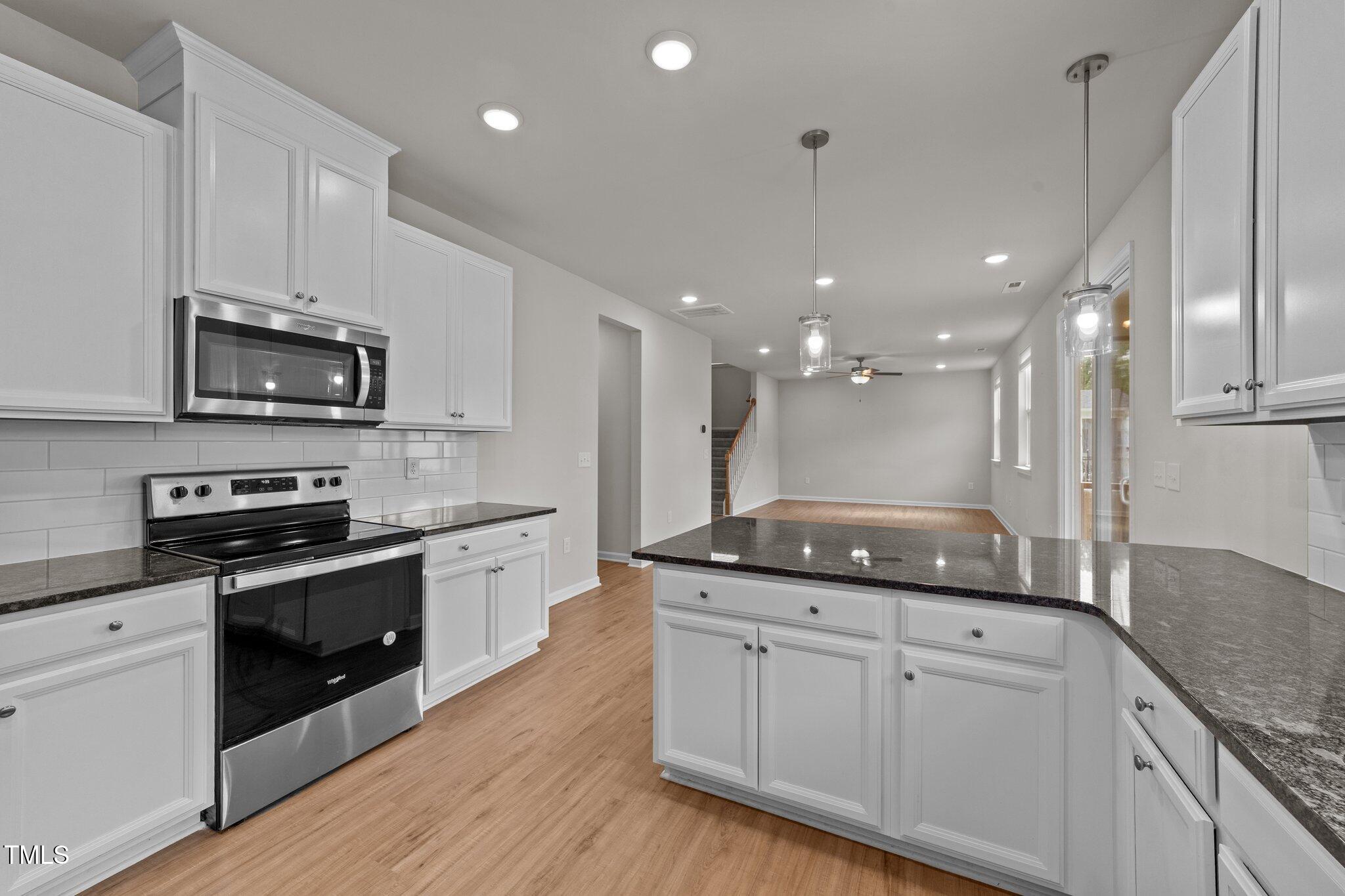 188 Karlov Road Garner, NC 27529 - Photo 13 of 38 a kitchen with kitchen island granite countertop stainless steel appliances a stove sink microwave and cabinets