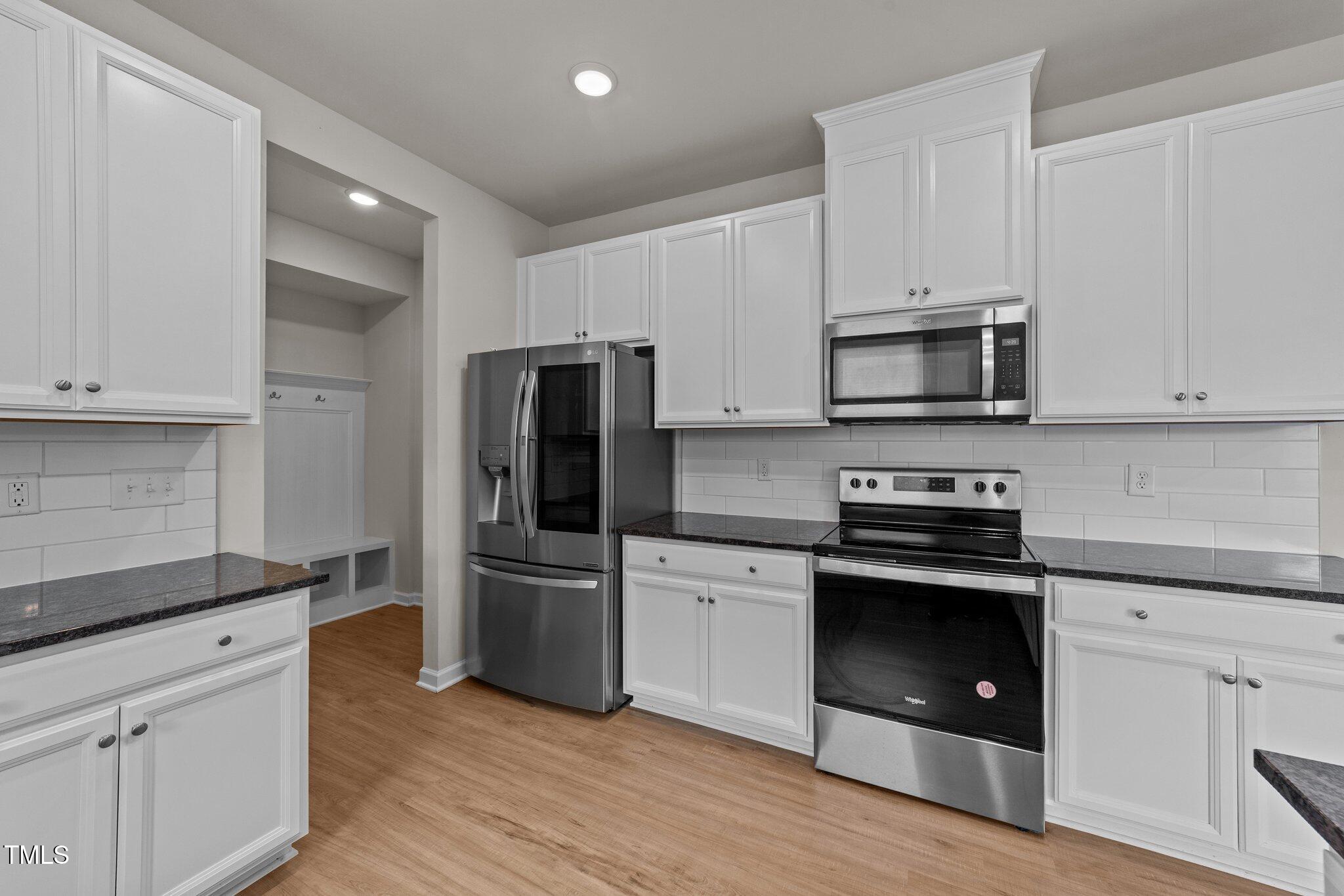 188 Karlov Road Garner, NC 27529 - Photo 14 of 38 a kitchen with cabinets stainless steel appliances and wooden floor