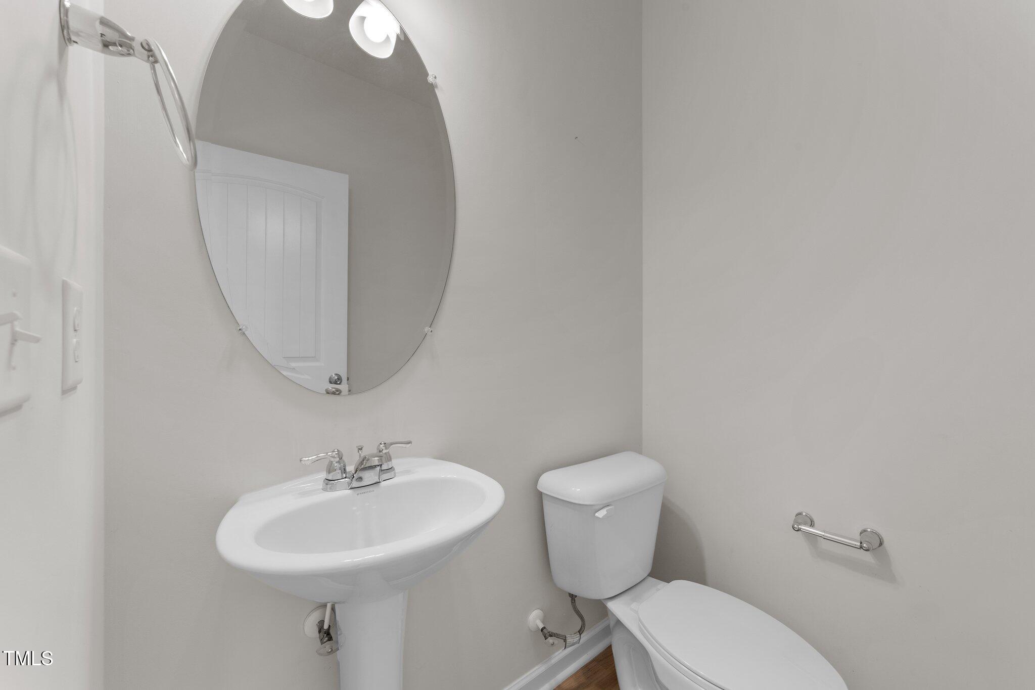 188 Karlov Road Garner, NC 27529 - Photo 17 of 38 a bathroom with a toilet a sink and mirror
