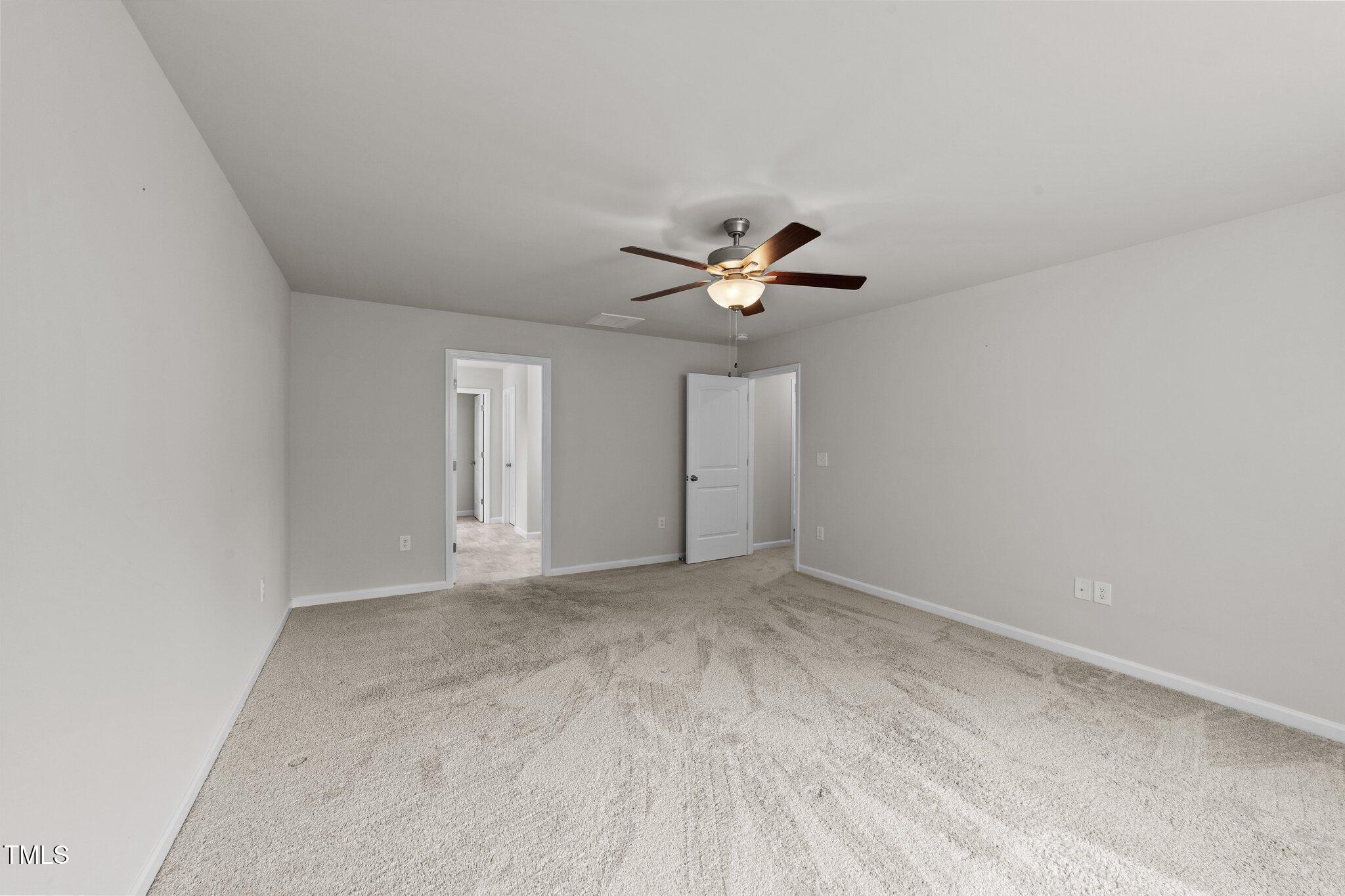 188 Karlov Road Garner, NC 27529 - Photo 21 of 38 an empty room with a chandelier fan and windows