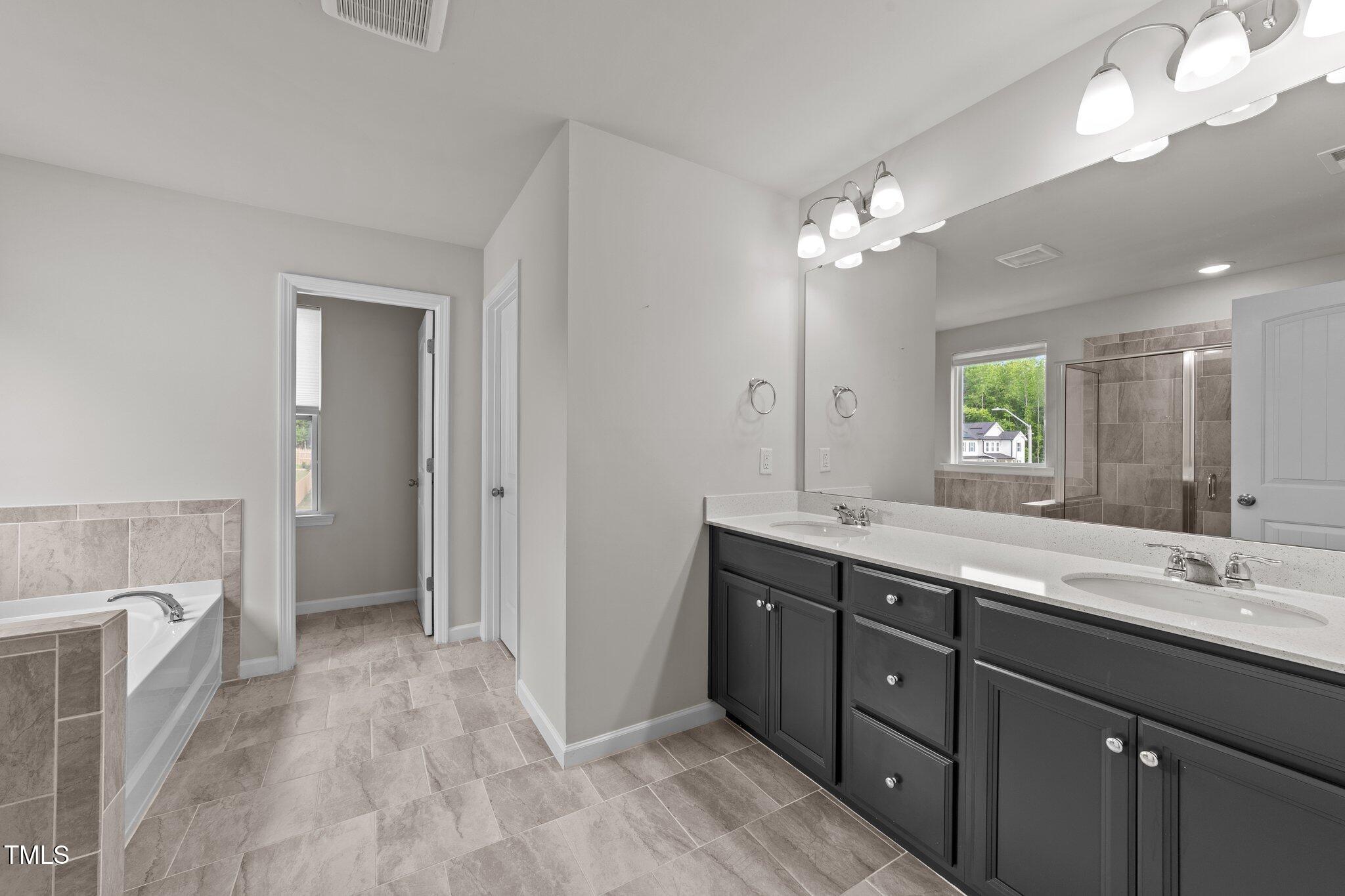 188 Karlov Road Garner, NC 27529 - Photo 22 of 38 a spacious bathroom with a double vanity sink a mirror and a shower