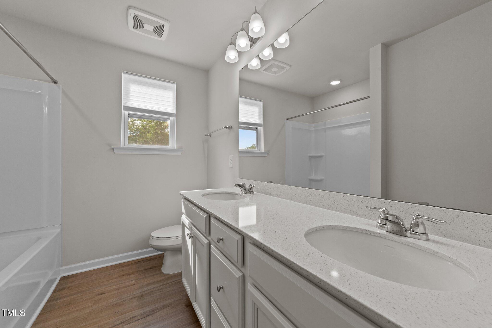 188 Karlov Road Garner, NC 27529 - Photo 29 of 38 a bathroom with a granite countertop sink a toilet and a mirror
