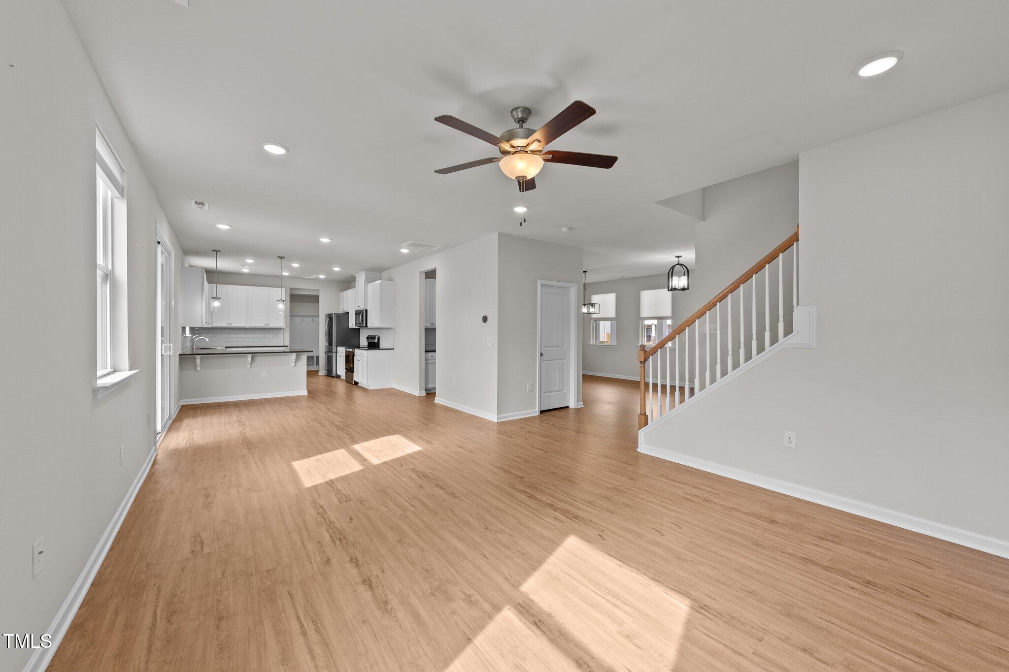 188 Karlov Road Garner, NC 27529 - Photo 8 of 38 a view of an empty room and kitchen view with wooden floor and a window