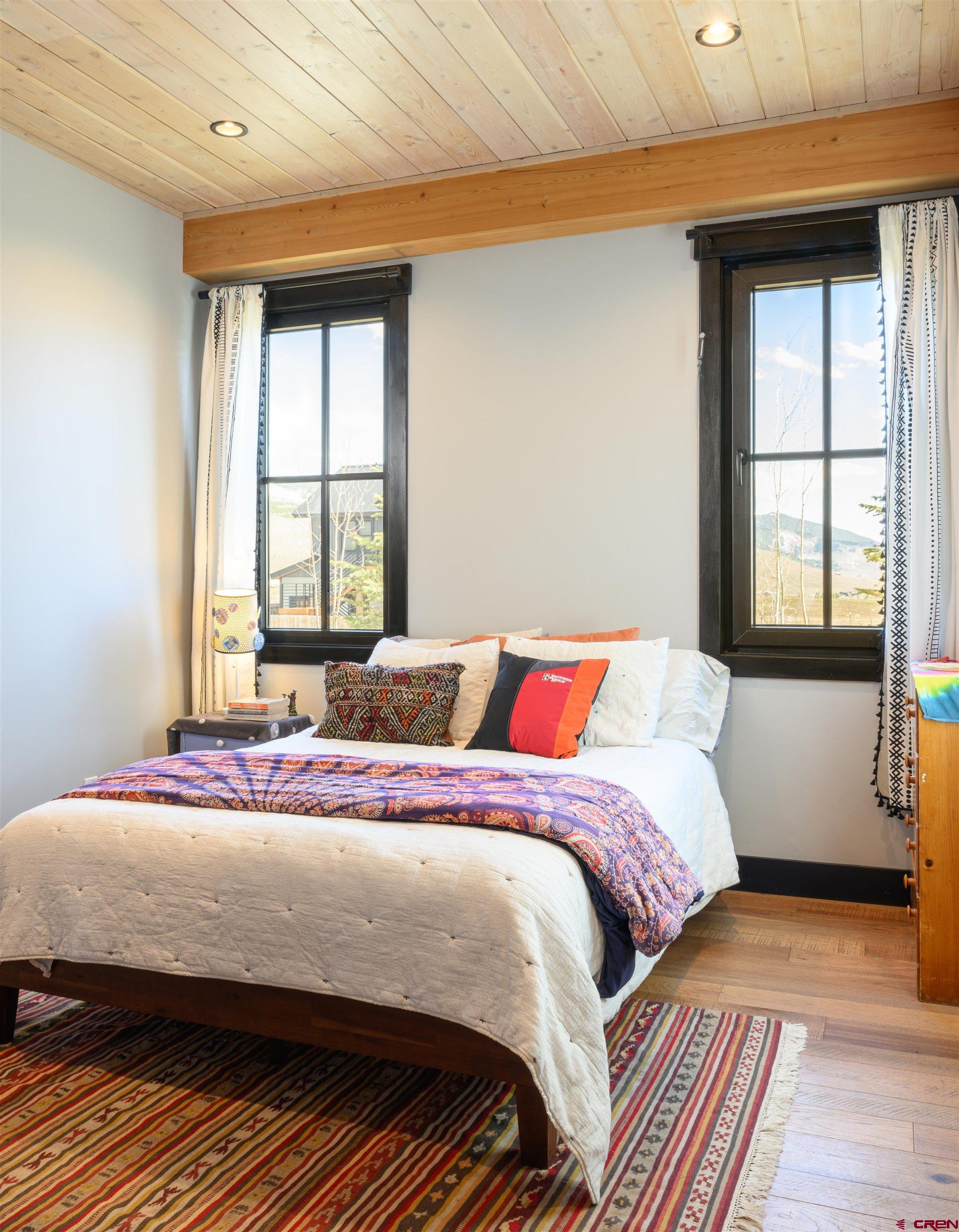 96 Chestnut Lane Crested Butte, CO 81224 - Photo 13 of 37 a bedroom with a bed and wooden floor