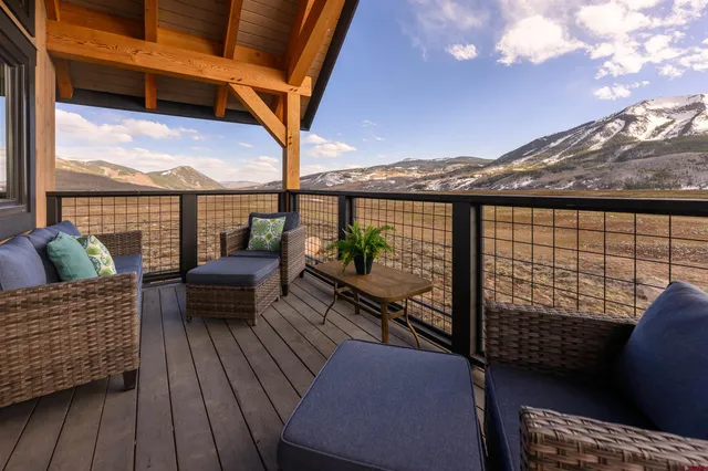 a balcony with wooden floor and outdoor seating