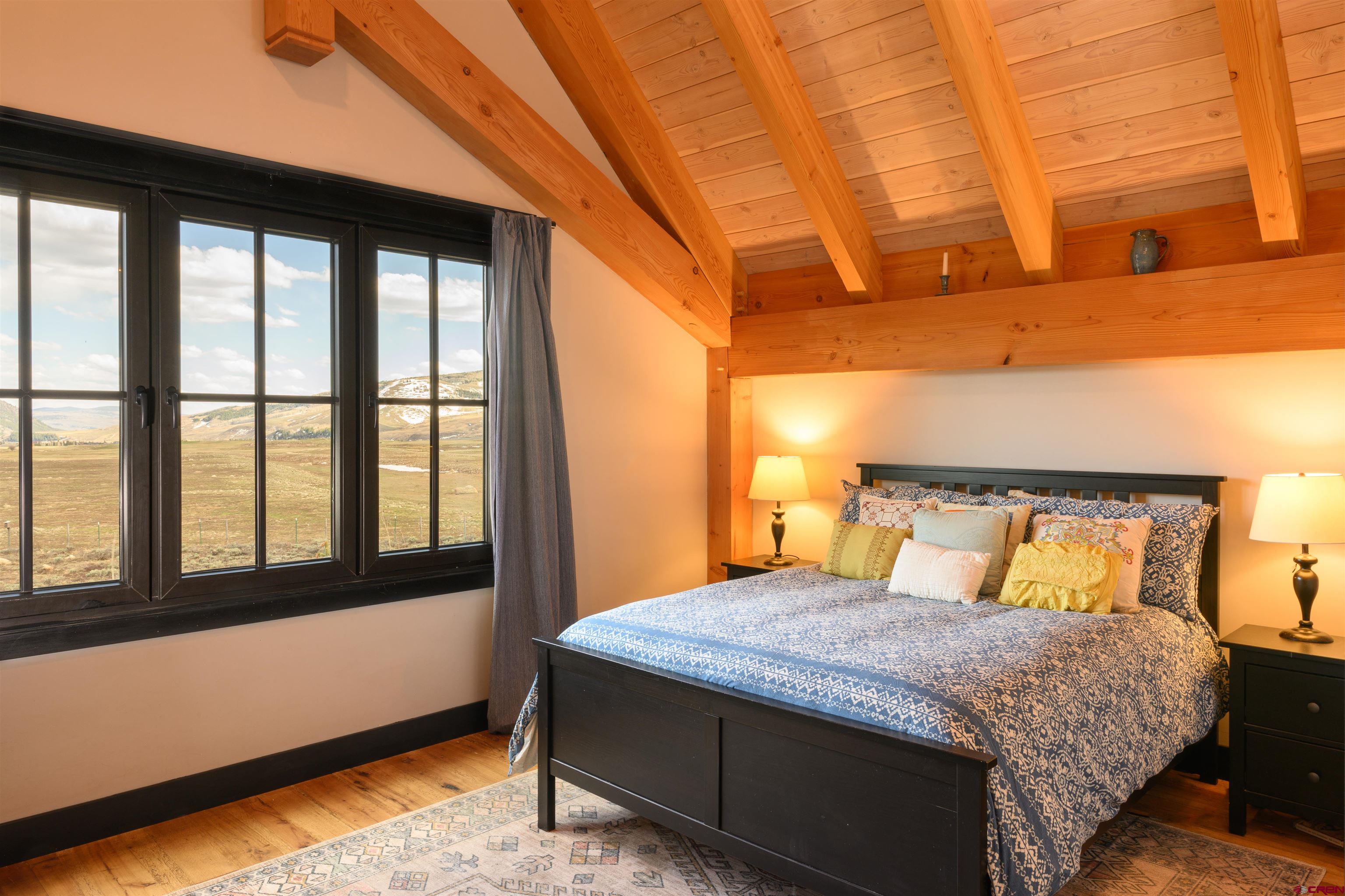 96 Chestnut Lane Crested Butte, CO 81224 - Photo 8 of 37 a bedroom with a large bed and a large window