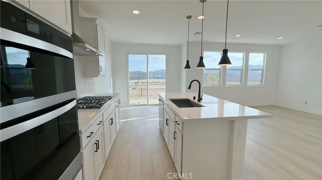 a kitchen with stainless steel appliances kitchen island a sink a stove and a window