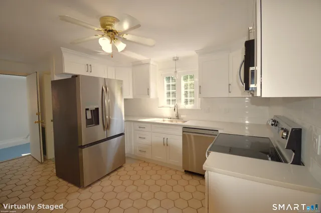 a kitchen with a refrigerator sink and cabinets