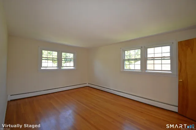a view of a room with wooden floor and window