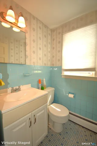 a bathroom with a toilet a sink and a mirror