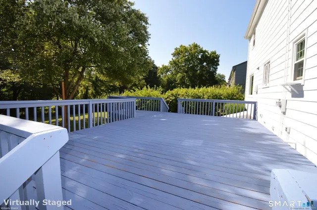 a view of a deck with two couches chairs and wooden floor
