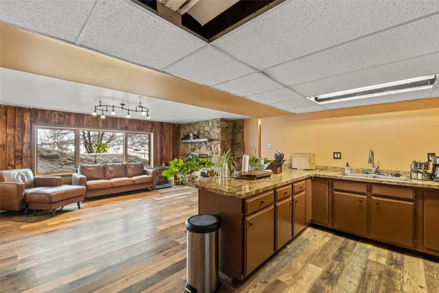a kitchen with stainless steel appliances kitchen island granite countertop a sink refrigerator and cabinets