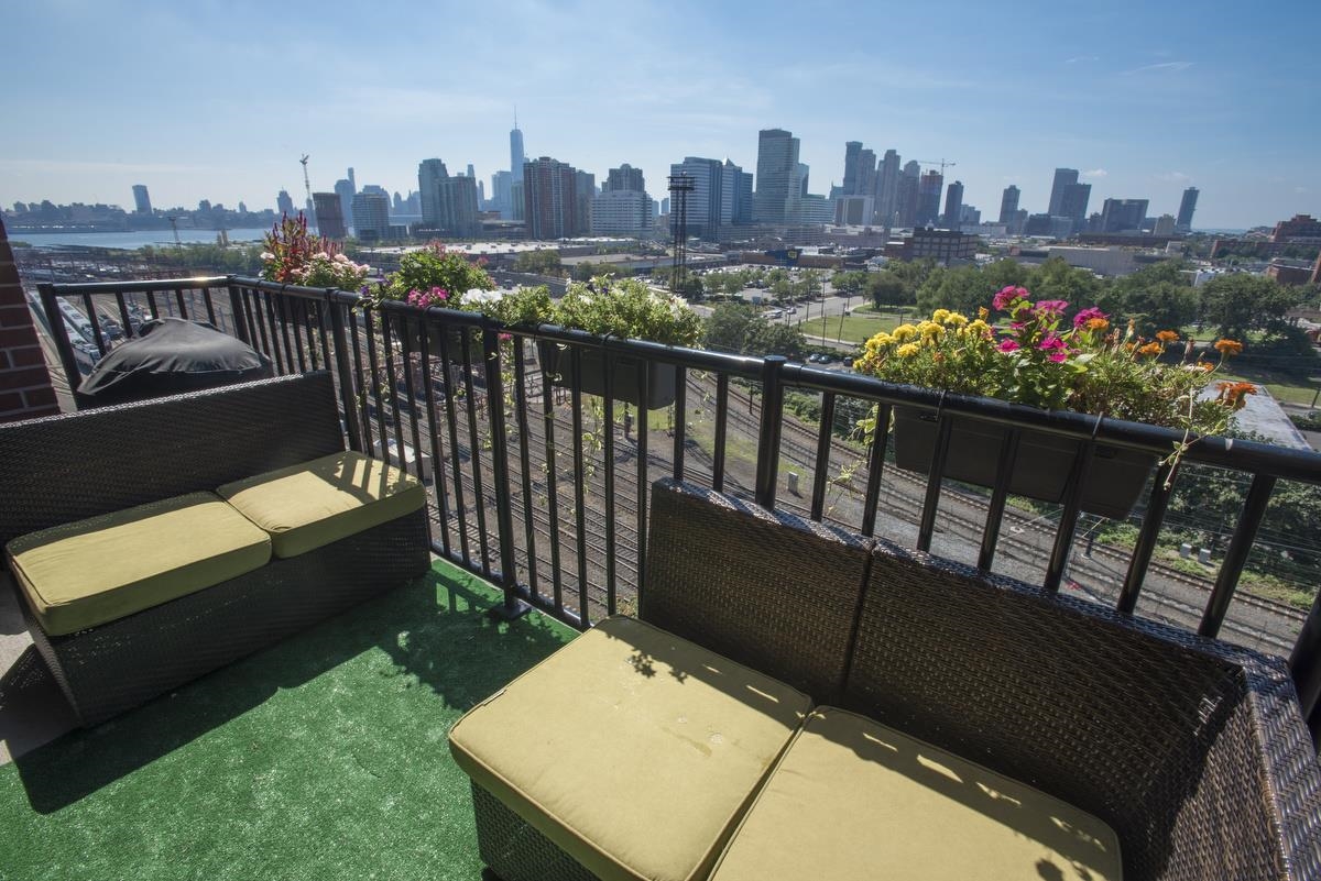 700 Grove Street, Unit 12J Jersey City, NJ 07310 - Photo 12 of 16 a view of a balcony with wooden benches