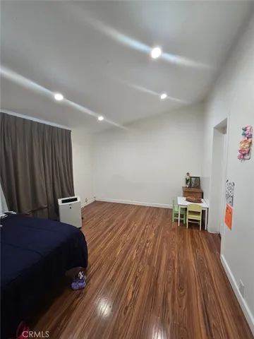 a bedroom with a bed and a wooden floor