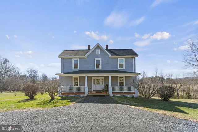 a front view of a house with a yard and large trees