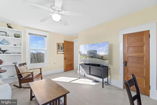 a living room with furniture a flat screen tv and a window