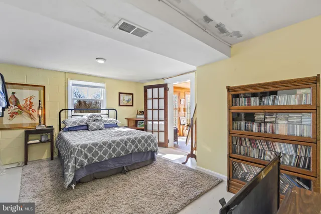 a bedroom with a large bed and a book shelf