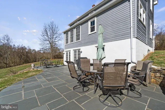 a view of a patio with table and chairs and floor to ceiling window