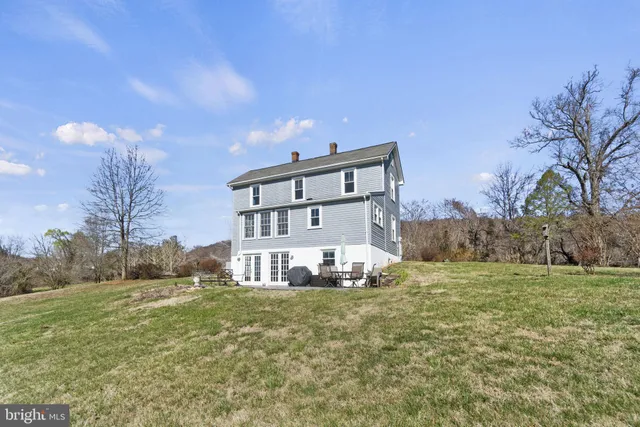 a view of a house with a big yard and a large tree
